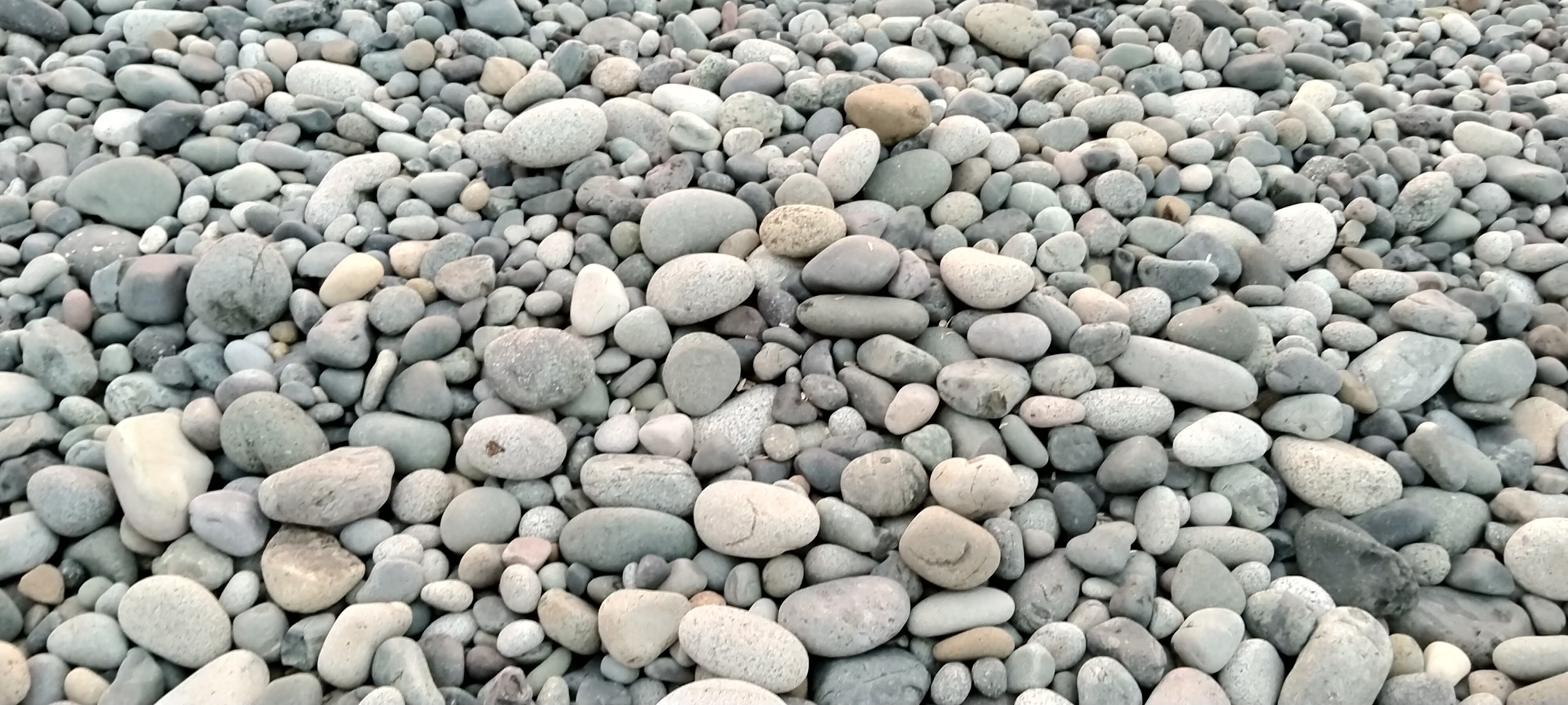The beach is covered in rocks as far as the eyes can see, and even further